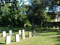The cemetery with the war memorial in the shade.